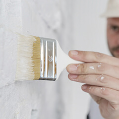 man painting brick white
