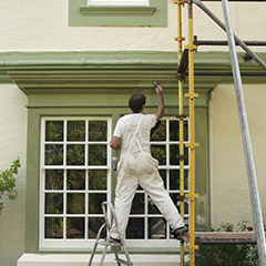Man on scaffold painting