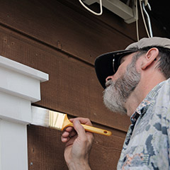 Man painting window trim