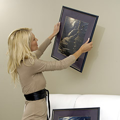 Woman removing painting from wall