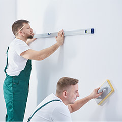 Two men prepping walls for painting
