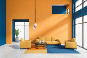 a decorated living room with contrasting colored furniture and walls