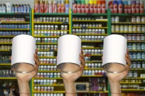 hands holding up three different paint cans in front of a shelve in a paint store