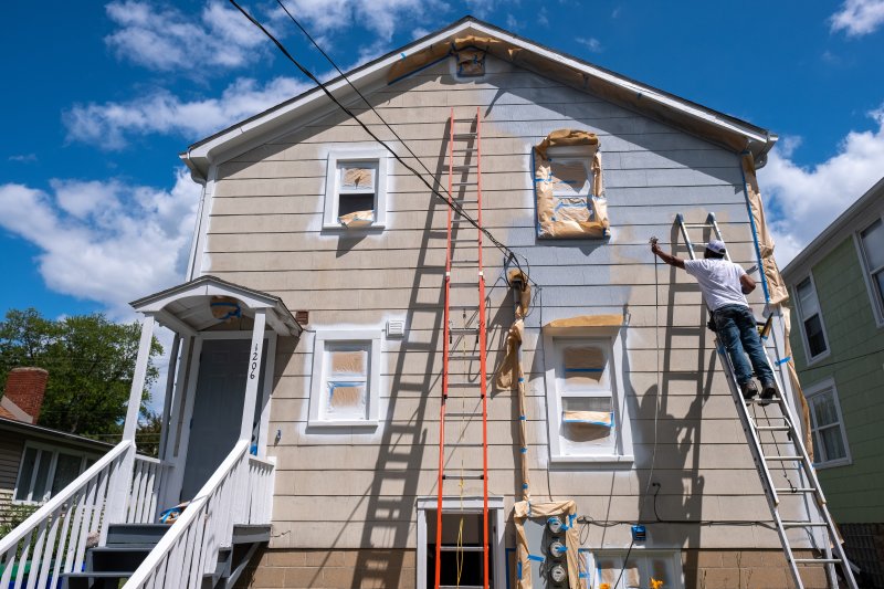 man prepping house to paint