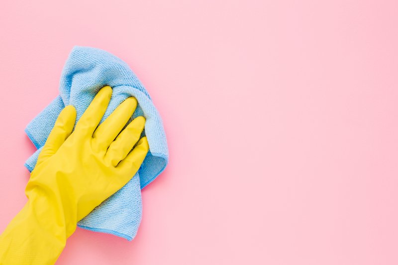 person cleaning a pink wall