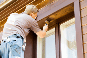 a person painting their home’s exterior